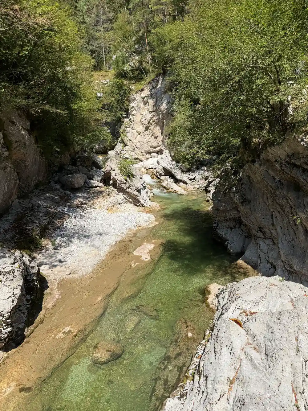 Clear green water among pale boulders