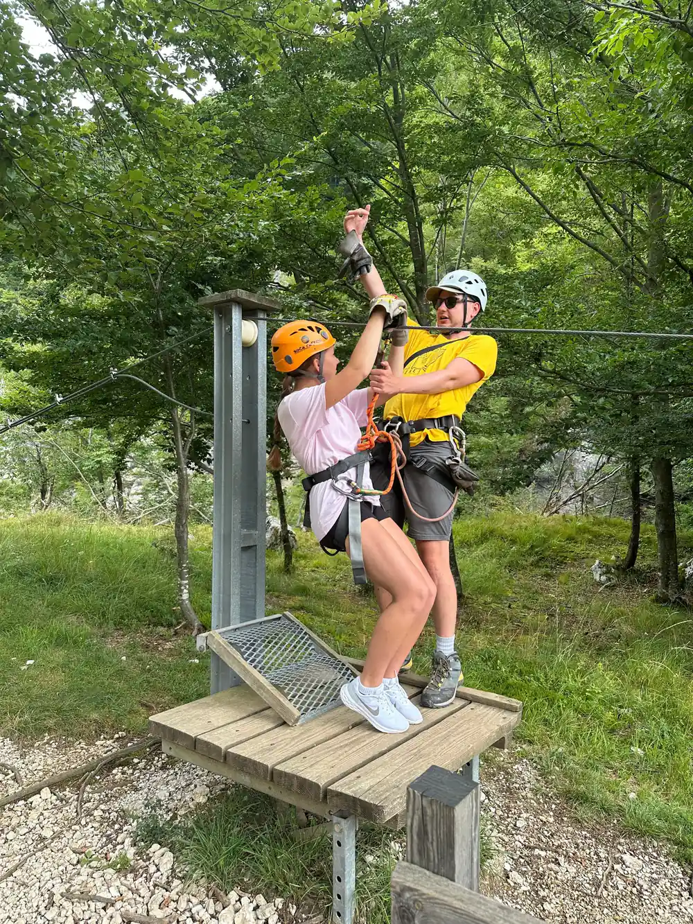 A guide clipping a rider onto the line at the platform